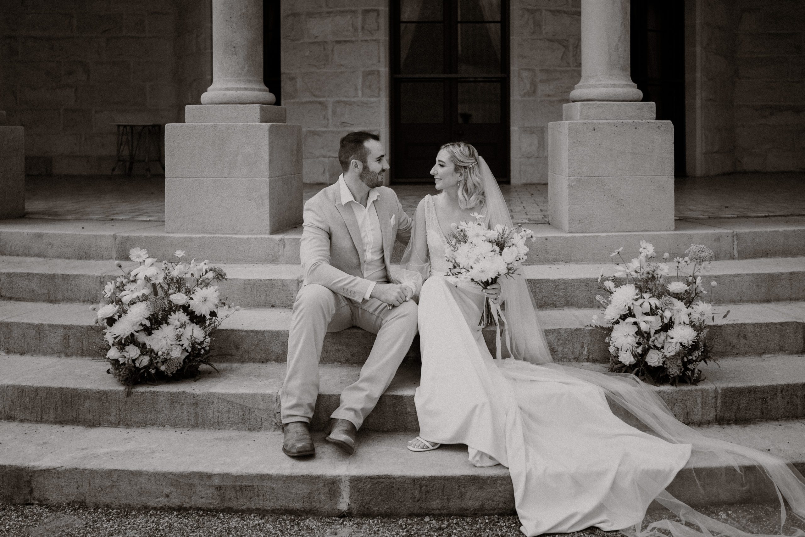 Bride and groom sitting on the steps at Jimbour House